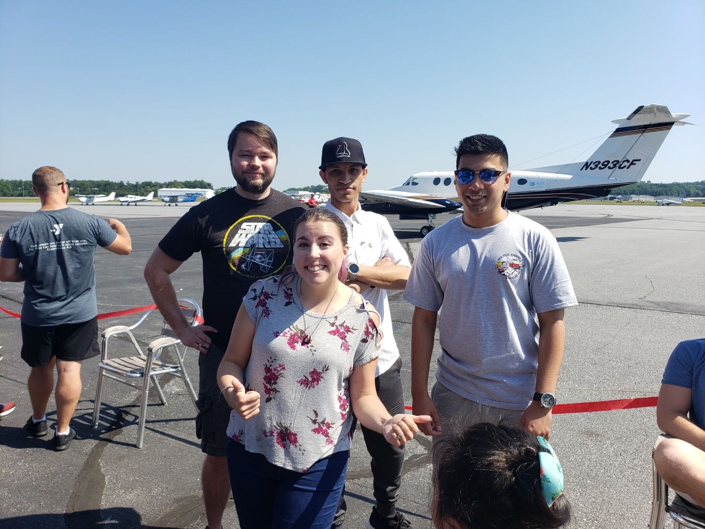 Group of people posing for a picture in the tarmac